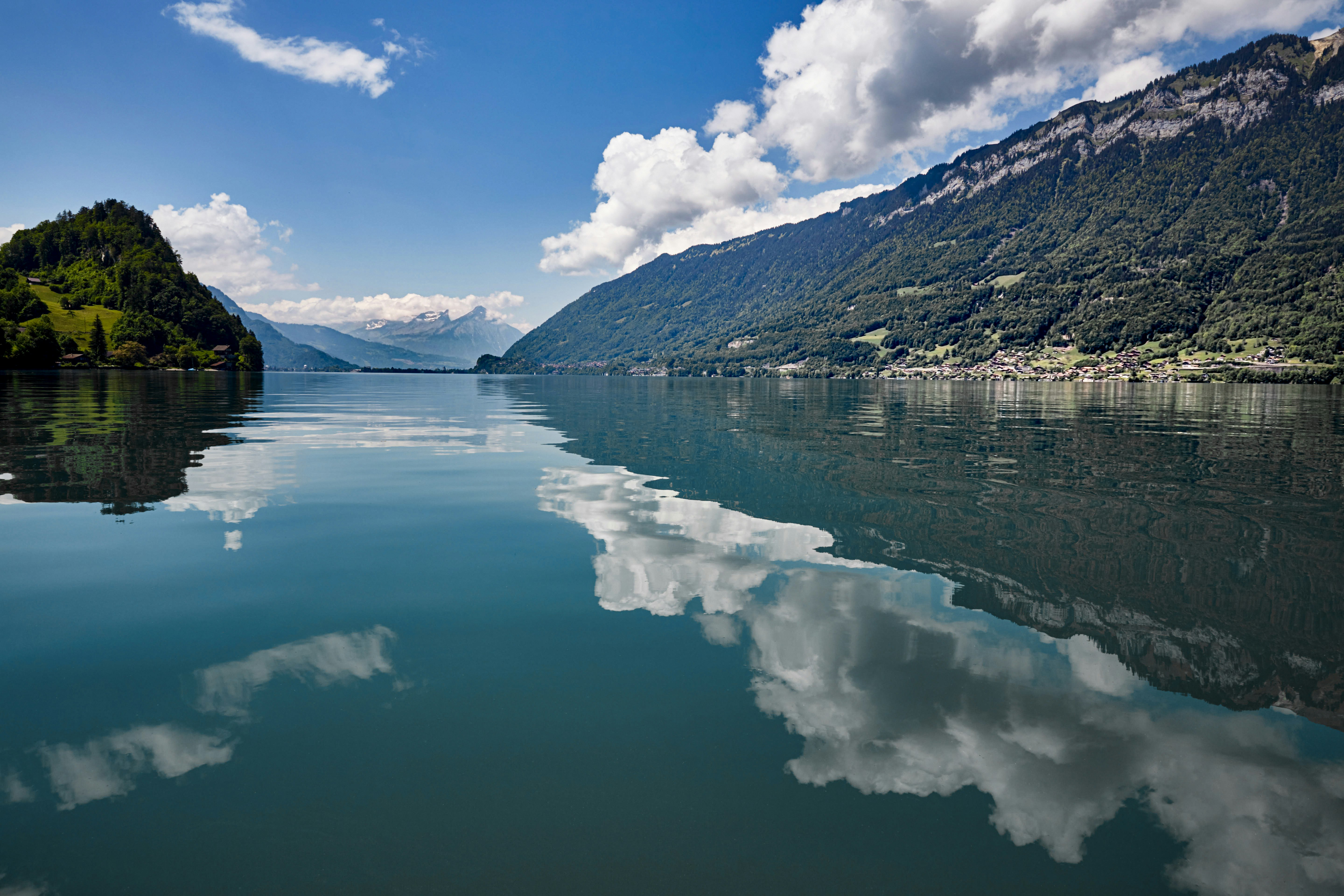 body of water near mountain under blue sky during daytime